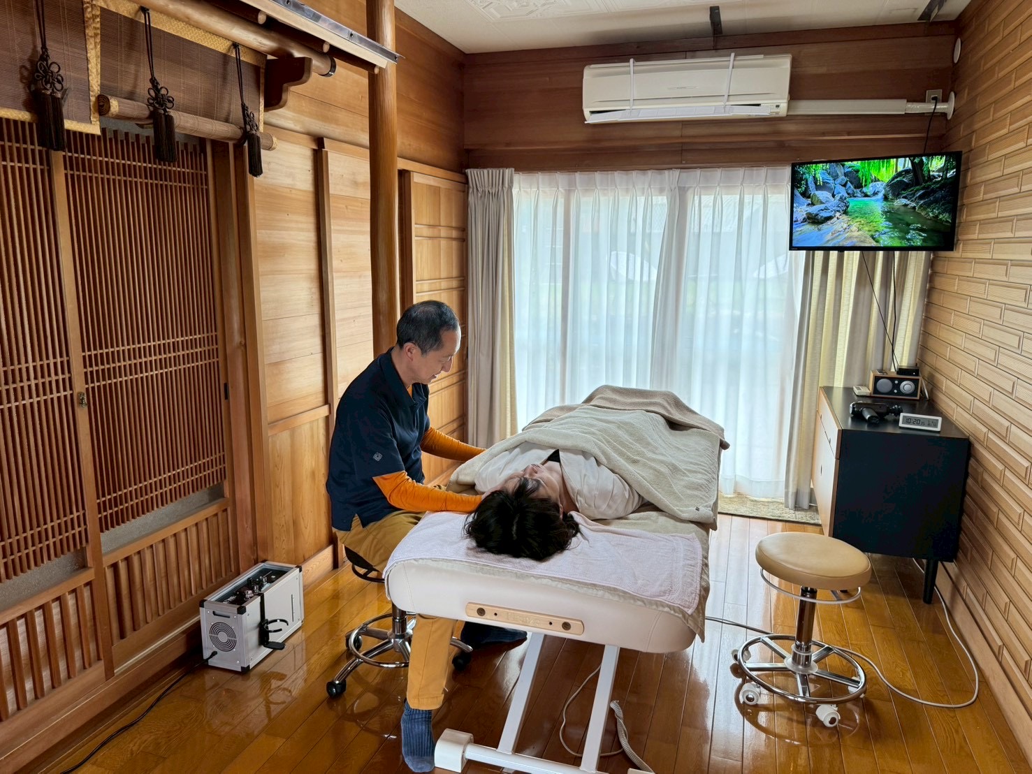 木の温もりがある施術室で施術を行う様子
