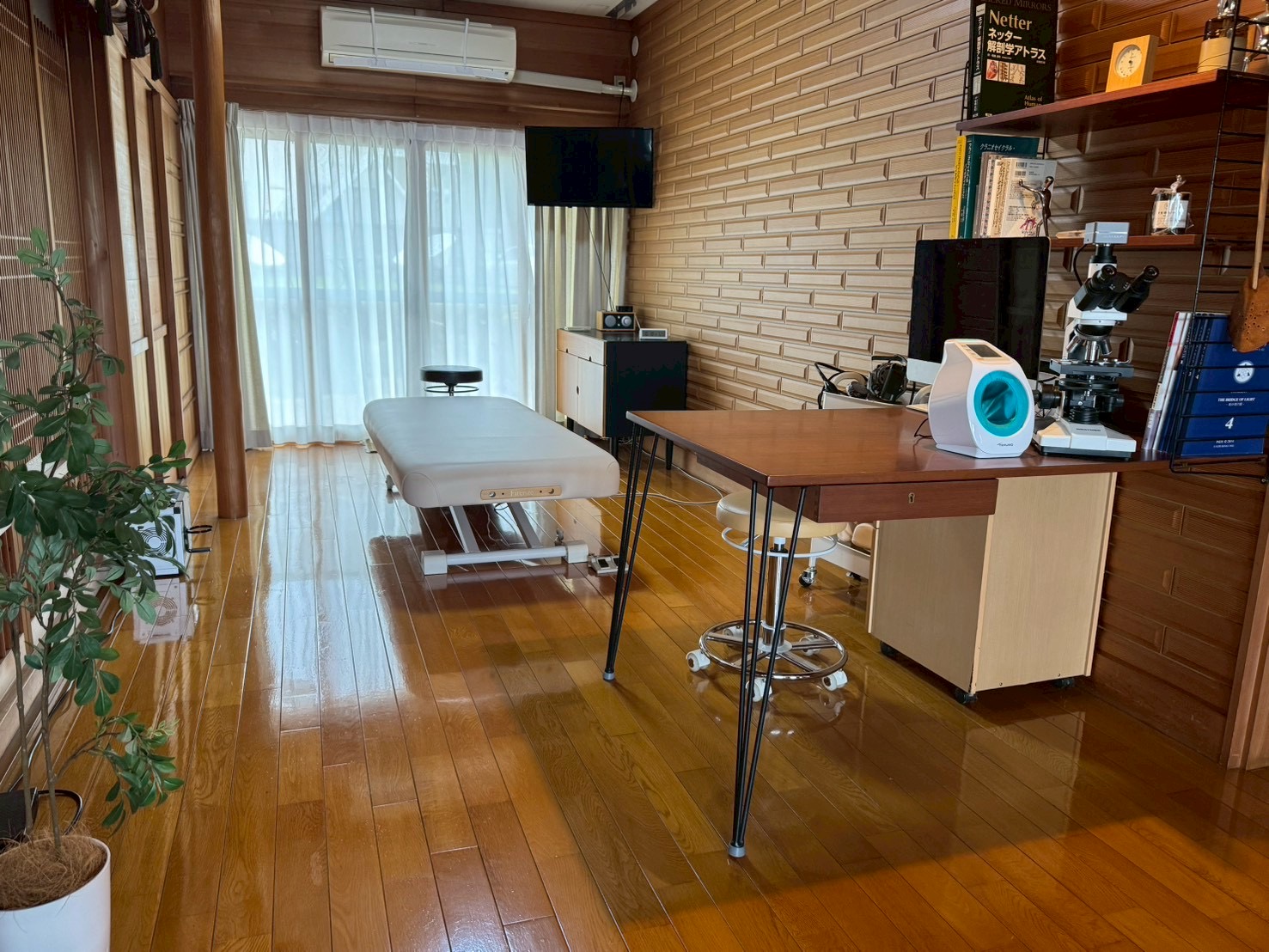 施術ベッドが置かれた木の温もりがある施術部屋